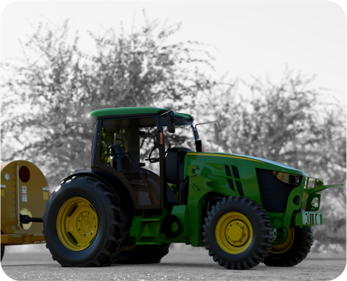 Green agricultural tractor with large tires, towing a yellow attachment, parked outdoors near trees.